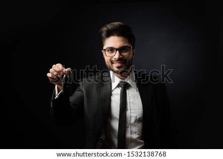 Indian businessman with Car Keys, standing isolated over black background