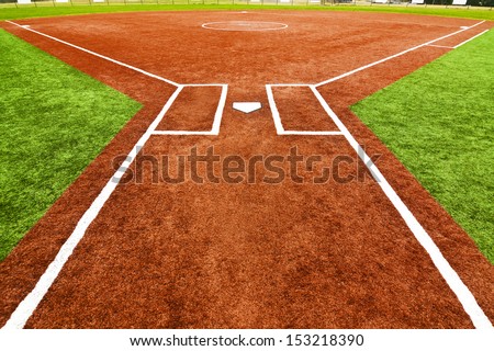 View from behind home plate looking towards the outfield across the pitcherÃ¢Â?Â?s mound with artificial turf field. The bright colors of the artificial turf are a high contrast to a normal playing field. Royalty-Free Stock Photo #153218390