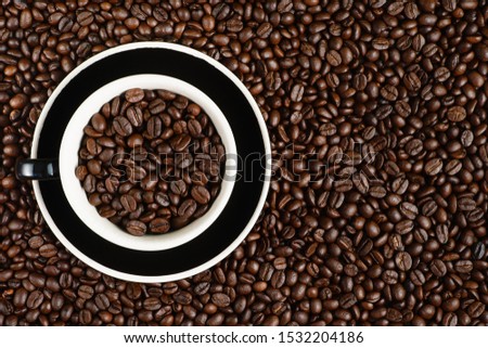 coffee background of coffee beens in red cup on roasted arabica coffee beans background