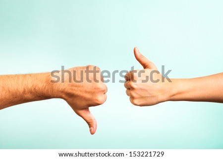 Two hands signalling thumbs up and thumbs down. The smooth hand on the left is making a thumbs up gesture while the hairy hand on the right is making a thumbs down gesture. Royalty-Free Stock Photo #153221729