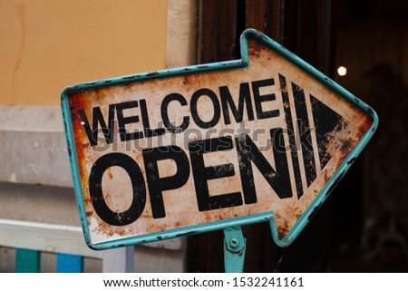 Welcome Open Sign. A business sign that says Come in We’re Open on cafe restaurant window