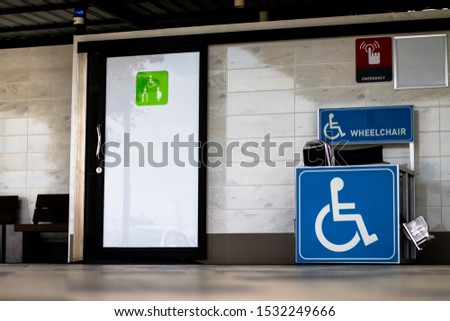Wheelchair symbol on Toilet in park,
Wheelchair signs on restroom.
