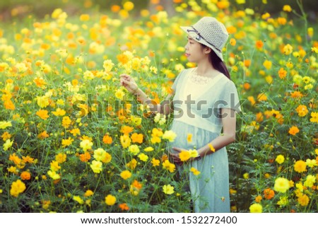 Pregnant woman are happy In the flower garden