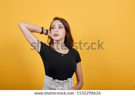 Girl putting her hands in her hairs as she poses for photo. She is being thoughtful and kinda candid type of picture it is.