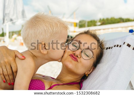 Mothers Day. Mom and son are on vacation together lying on a deck chair. family vacation at sea