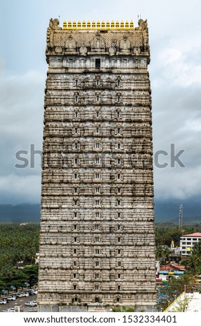 Magnificent 20-storeyed Gopuram at entrance of Lord Shiva Temple in Murdeshwara. Focus on top floors. This stone structure is constructed in traditional Dravidian architecture of Medieval South India. Royalty-Free Stock Photo #1532334401