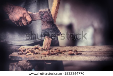Old men use axes to decorate the wood in the household industry.
