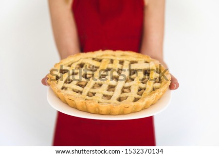 Woman in red holding plate with apple pie Royalty-Free Stock Photo #1532370134