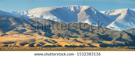 Typical landscapes of Mongolia. Snow on the peaks, desert mountain slopes and valleys. Royalty-Free Stock Photo #1532383136