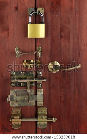 Metal bolts, latches and hooks in wooden door close-up