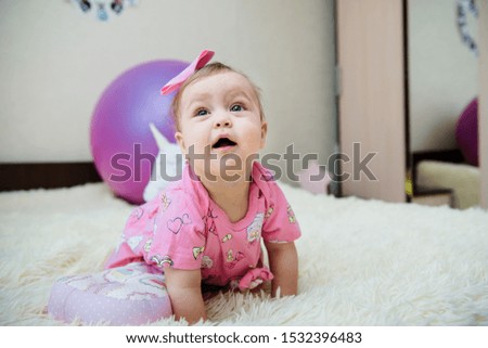 Little girl playing on the bed with her toys.