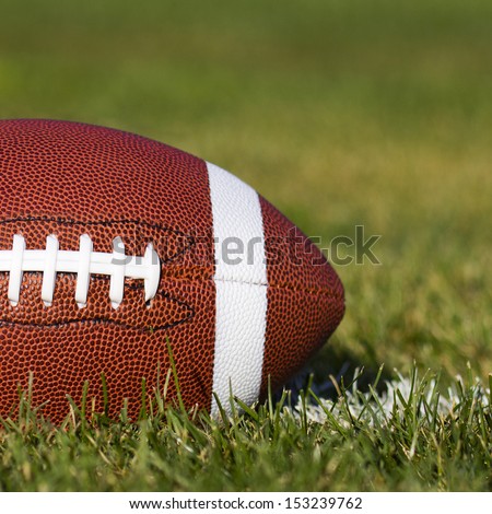 American Football on the field with yard line and green grass. Closeup