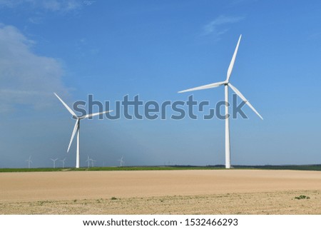 Picture of wind power towers located in a field and producing green energy, environment background, renewable energy, alternative..