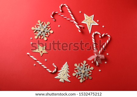 Candy canes and christmas accessories on red background, space for text
