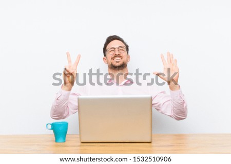 young handsome businessman smiling and looking friendly, showing number seven or seventh with hand forward, counting down