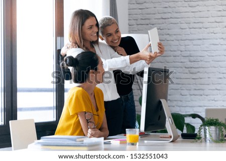 Shot of three modern businesswomen taking a selfie with digital tablet while working in the office.