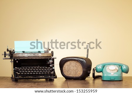 Vintage typewriter, old radio, retro telephone on wood table