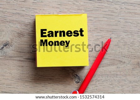 Earnest money text written in a sticky note. View from above
