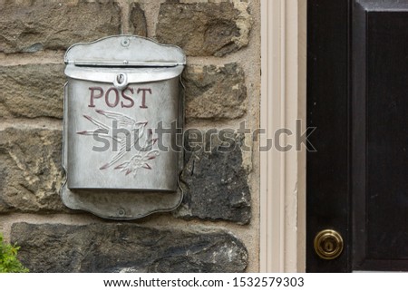 vintage tin mailbox stone front house