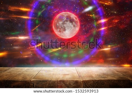 Holidays Halloween concept. Empty rustic table in front of scary and misty night sky and full moon background. Ready for product display montage