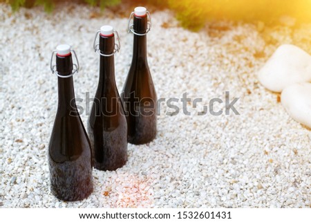 Black bottles for wine storage, isolated on white stones.