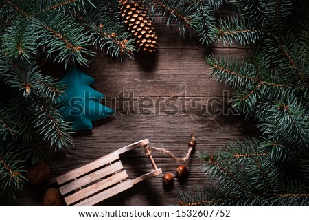 Christmas frame from fir branches on a background of an old gray board around an open notebook with blank sheets. Frame of fir branches. Christmas card blank concept.