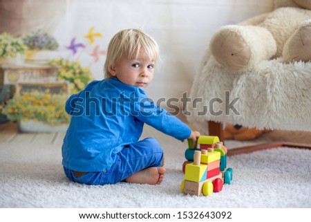 Sweet toddler child, playing doctor, examining teddy bear toy at home, isolated background