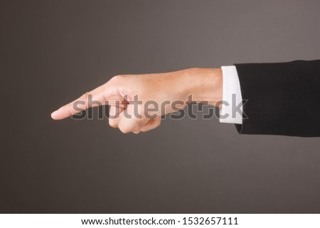 Close up of Asian Male Hand on gray Background in studio Taking With Studio Light. Pointing Action.
