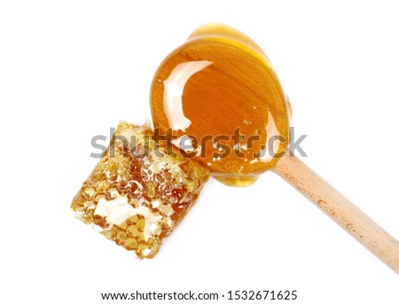Honey covered honeycomb piece with wooden spoon, isolated on white background, top view