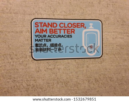 A signage found inside male toilet- Stand Closer, Aim Better