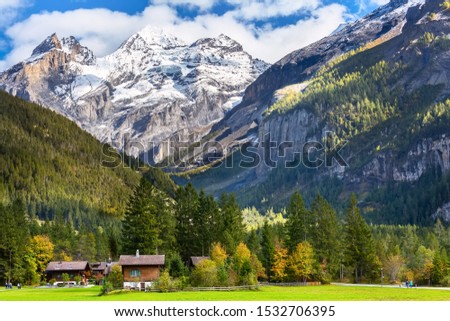 Colorful wooden houses in Kandersteg village, Canton Bern, Switzerland, Europe and snow mountains panorama Royalty-Free Stock Photo #1532706395