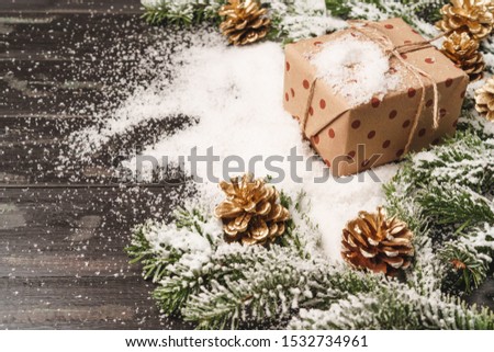 Beautiful Christmas gift with snowy holiday decorations on table