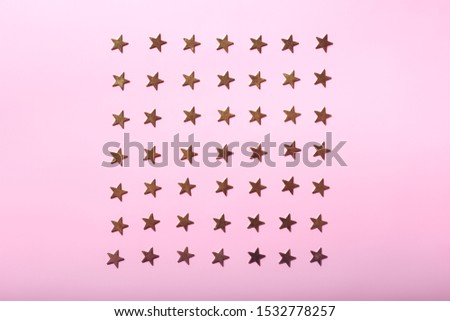Flat lay composition with golden stars on bright pink background, festive concept
