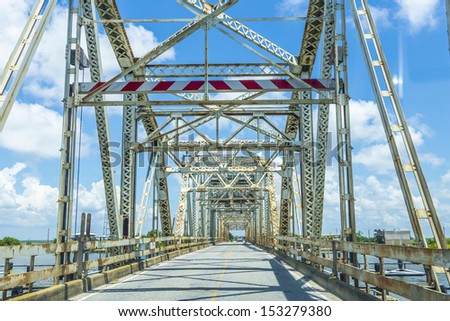 driving on Chef Menteur Highway with old bridge in East area of New Orleans crossing the bay