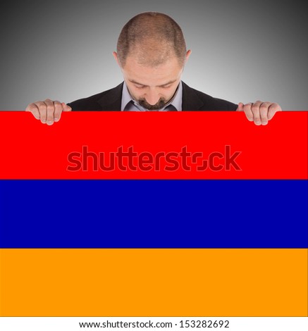 Businessman holding a big card, flag of Armenia, isolated on white