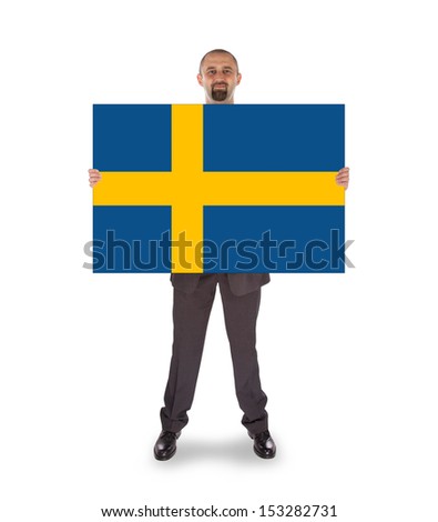 Smiling businessman holding a big card, flag of Sweden, isolated on white