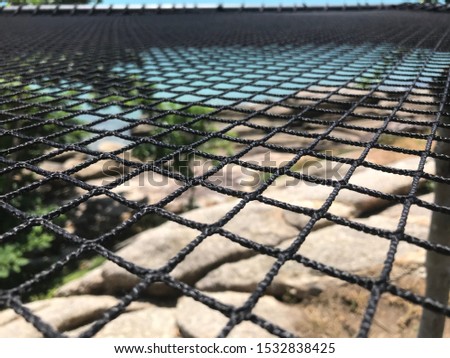 Picture of rope mesh. A close up and blur for rope mesh With sea and rocks as a background