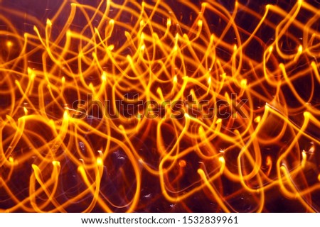 Abstract orange lights shot with long exposure. Motion background, Glowing yellow lines photographed with slow shutter speed. 