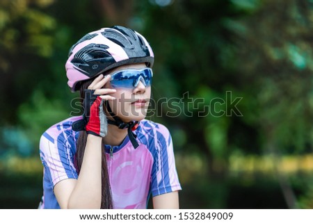 Close up Portrait of beautiful young woman riding her bike in outdoors, exercise for health care in the park