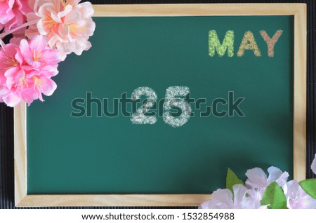 May month write with colorful chalk, flowers on the board, Date 25.