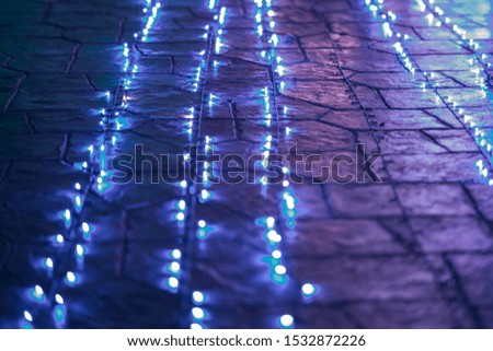 Colorful wire LED lights on white wire, lying on the floor. New Year, Christmas and celebration decoration.