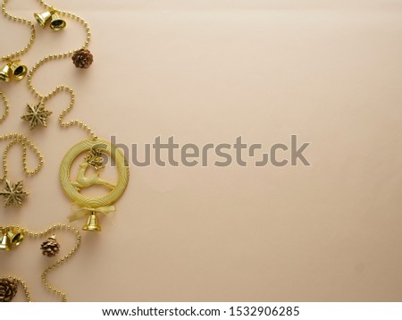 Christmas decorations in gold colors on beige background. Holiday and celebration concept for postcard design. Top view, space for text.