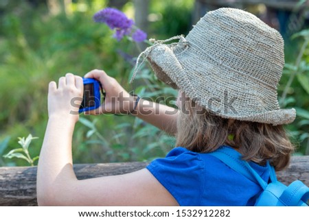 Little girl taking pictures with a blue camera