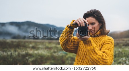 photographer traveler take photo on video camera closeup on background autumn foggy mountain, tourist shooting nature mist landscape, hobby vacation concept, copy space mockup