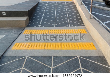Concrete ramp way with stainless steel handrail with disabled sign for support wheelchair disabled people. Ramp way to support wheelchair disabled people.