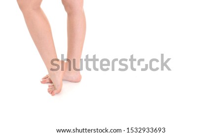 Low section close-up of slim female legs and feet on white background