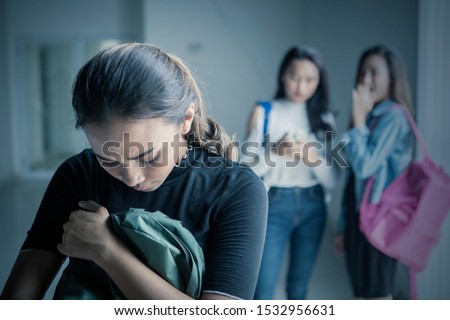Picture of sad teenage girl bullied with her friends in the classroom Royalty-Free Stock Photo #1532956631