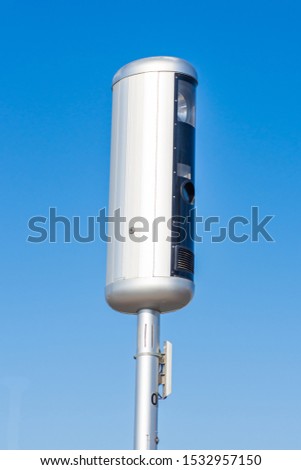 Traffic speed camera on a blue sky background preparing to use technology to stop speeding in cars on the road
