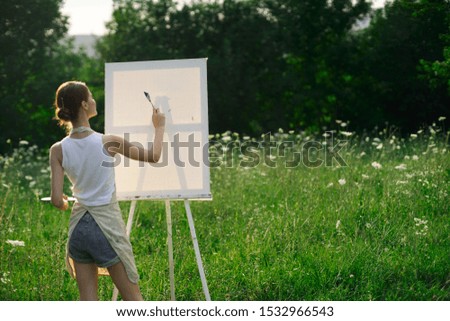 young woman in nature with white blank canvas