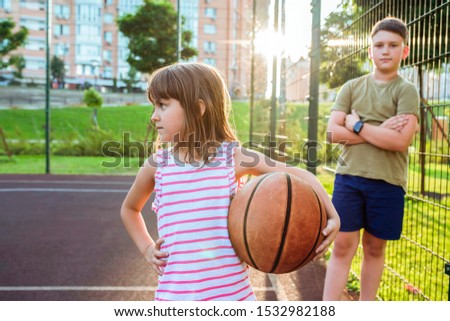Children with a ball on an open basketball court. Healthy lifestyle and sport concepts.